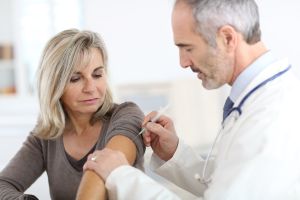 Žena při očkování u lékařa